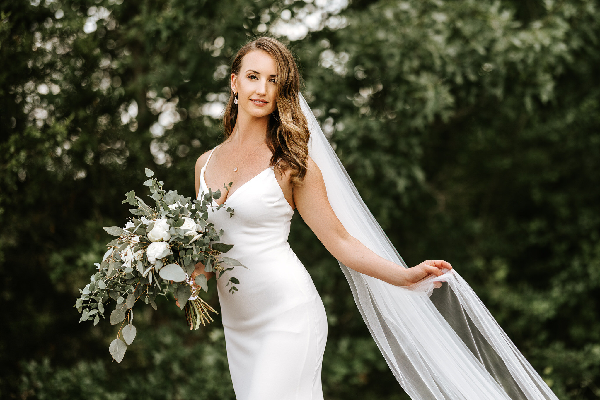 Bridal dramatic portrait standing by trees at stone crest venue